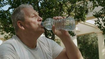 Elderly man drinks water bottles video