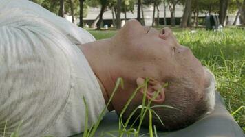 Old caucasian man meditates in the park video