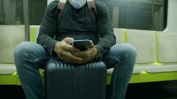 Mens reiziger met koffer gebruik makend van telefoon in metro trein video