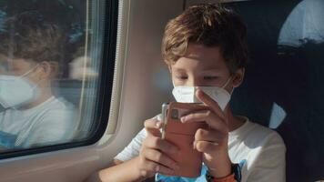 Boy filling in journey time by playing mobile games video