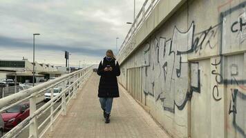 femme en marchant dans une ville district éclaboussé avec graffiti video