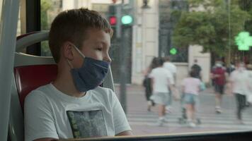 negen jaren oud jongen met een gezicht masker in de bus video