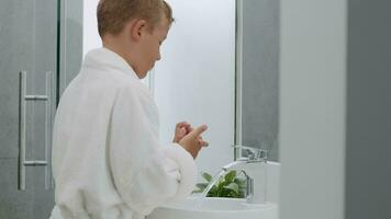 enfant la lessive mains dans salle de bains. il toujours garde le sien mains nettoyer video