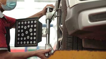 asiático hombre coche mecánico prensa el cambiar coche levantar máquina va arriba en el levantar en el auto garaje de reparación. foto