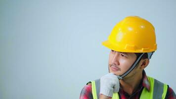 Asian young engineer wearing a yellow safety goggles and safety vest. looking to the side and smiling. photo