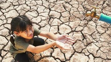 Asian girl rural sitting on dry ground. Water crisis, Concept hope and drought. photo