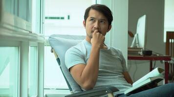 Asian man with attractive handsome reading a book at home, 30-39 year old. photo