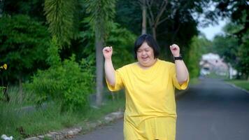 asiático mujer con abajo síndrome es contento a imagina su cruce el terminar línea. foto