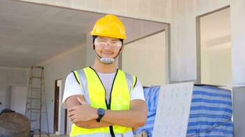 un joven elegante, capataz, mira a el construcción , vistiendo un protector casco. concepto bueno trabajar, proyecto. foto