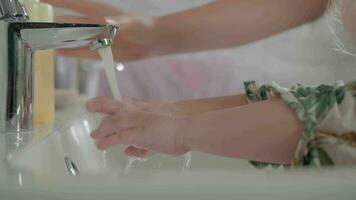 Mom engraining child healthy habit of washing hands video