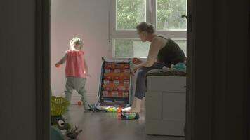 juguetón pequeño niña con mamá a hogar video