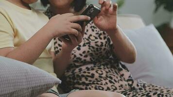 smiling father and daughter taking selfie on smartphone while mother and son using laptop together at home video