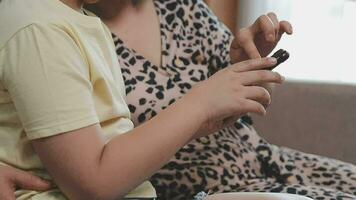 glimlachen vader en dochter nemen selfie Aan smartphone terwijl moeder en zoon gebruik makend van laptop samen Bij huis video