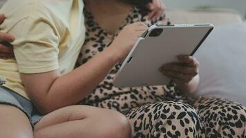 sorridente padre e figlia assunzione autoscatto su smartphone mentre madre e figlio utilizzando il computer portatile insieme a casa video