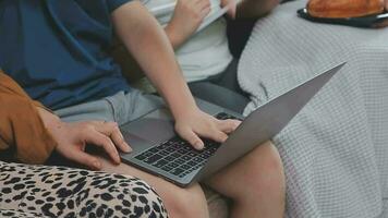 smiling father and daughter taking selfie on smartphone while mother and son using laptop together at home video