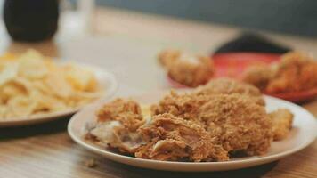 detailopname beeld van een mooi Aziatisch vrouw genieten aan het eten Frans Patat en gebakken kip in restaurant video