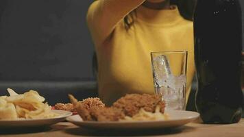 fechar-se imagem do uma lindo ásia mulher apreciar comendo francês fritas e frito frango dentro restaurante video