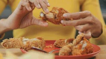 fechar-se imagem do uma lindo ásia mulher apreciar comendo francês fritas e frito frango dentro restaurante video