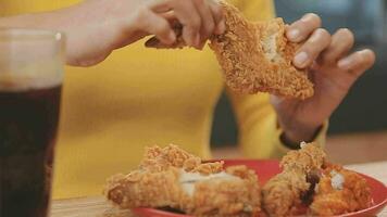 närbild bild av en skön asiatisk kvinna njut av äter franska frites och friterad kyckling i restaurang video
