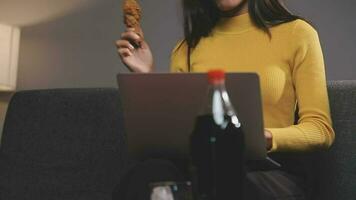 avvicinamento Immagine di un' bellissimo asiatico donna godere mangiare francese patatine fritte e fritte pollo nel ristorante video