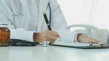 Professional female doctor smiles and shows positive examination results to young, joyful man. Handsome, happy guy with glasses at doctor's appointment in modern office of medical institution. video