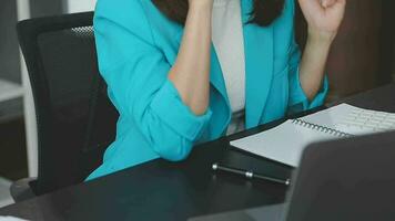 Beautiful young smiling Asian businesswoman working on laptop and drinking coffee, Asia businesswoman working document finance and calculator in her office. video