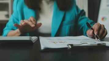 Close up Businesswoman using calculator and laptop for do math finance on wooden desk in office and business working background, tax, accounting, statistics and analytic research concept video