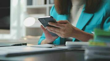 Portrait of a happy Asian businesswoman using mobile phone indoor, Asian businesswoman working in modern office. video