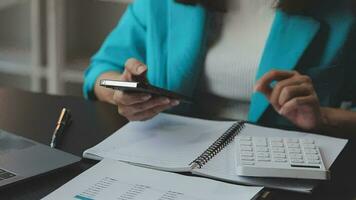 Close up Businesswoman using calculator and laptop for do math finance on wooden desk in office and business working background, tax, accounting, statistics and analytic research concept video