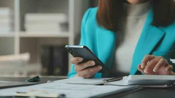 Close up Businesswoman using calculator and laptop for do math finance on wooden desk in office and business working background, tax, accounting, statistics and analytic research concept video