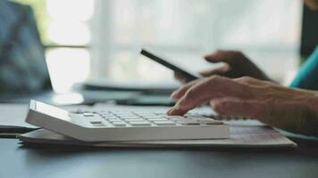 Close up Businesswoman using calculator and laptop for do math finance on wooden desk in office and business working background, tax, accounting, statistics and analytic research concept video