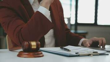 rättvisa och lag koncept.manlig domare i en rättssal med klubban, arbetar med, dator och dockningstangentbord, glasögon, på bordet i morgonljus video