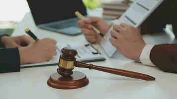 Justice and law concept.Male judge in a courtroom with the gavel, working with, computer and docking keyboard, eyeglasses, on table in morning light video