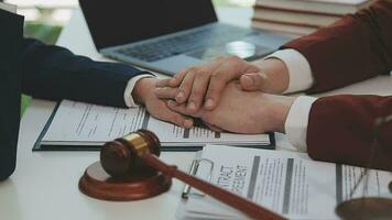 concetto di giustizia e diritto. giudice maschio in un'aula di tribunale con il martelletto, lavorando con computer e tastiera docking, occhiali, sul tavolo alla luce del mattino video