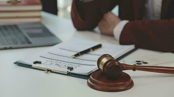 concetto di giustizia e diritto. giudice maschio in un'aula di tribunale con il martelletto, lavorando con computer e tastiera docking, occhiali, sul tavolo alla luce del mattino video