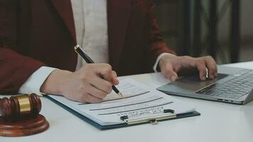 rättvisa och lag koncept.manlig domare i en rättssal med klubban, arbetar med, dator och dockningstangentbord, glasögon, på bordet i morgonljus video