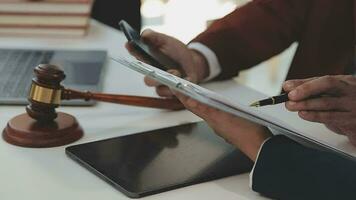 concetto di giustizia e diritto. giudice maschio in un'aula di tribunale con il martelletto, lavorando con computer e tastiera docking, occhiali, sul tavolo alla luce del mattino video