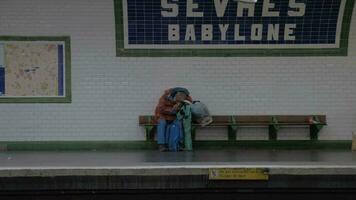 sem teto homem dormindo às sevres-babylone metrô estação dentro Paris, França video