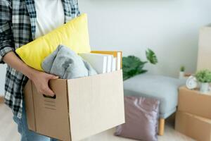 Moving house, relocation. Woman hold carton box contain equipment for new condominium, inside the room was a cardboard box containing personal belongings and furniture. move in the apartment photo