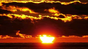 zonnig vurig zonsondergang door de oceaan. toneel- zonsondergang door de wolken Bij de zee video