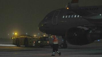 Tug towing Aeroflot A320 at winter night, Moscow video