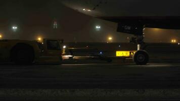 Aircraft towing tractor pulling Boeing 777 at night video