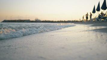 Sea waves washing the shore of resort at sunset video