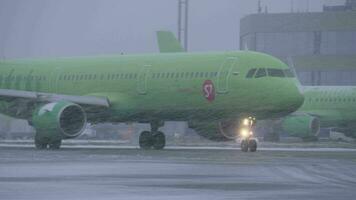 Flugzeug von s7 Fluggesellschaften Fahren auf Runway beim domodedowo Flughafen, Aussicht im Schneefall video