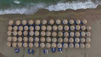 espreguiçadeiras às a de praia com poucos pessoas relaxante lá, aéreo Visão video