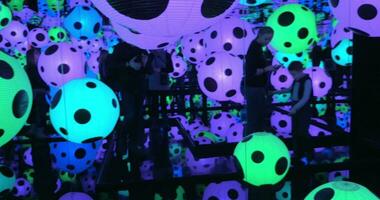 Visitors in Infinity Mirrored Room with colorful illuminated balls video