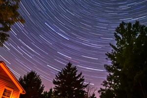 star trails in the night sky over a house and trees generative AI photo