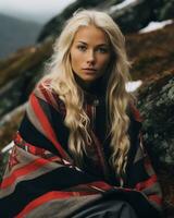 a blonde woman in a blanket sitting on top of a mountain generative ai photo
