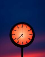 a clock with roman numerals on it against a red sky generative ai photo