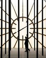 un hombre caminando mediante un habitación con un grande reloj generativo ai foto